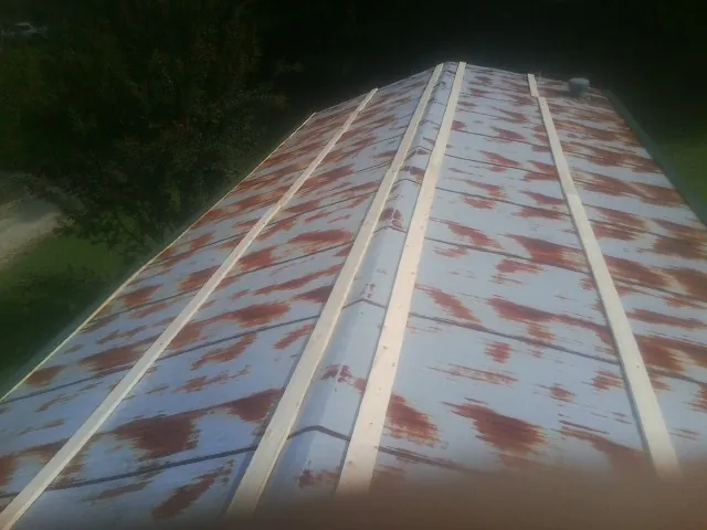 Rusted metal roof panels with new wood purlins before replacement — Storm Damage Roof Repair in Syosset by Roofing Brothers