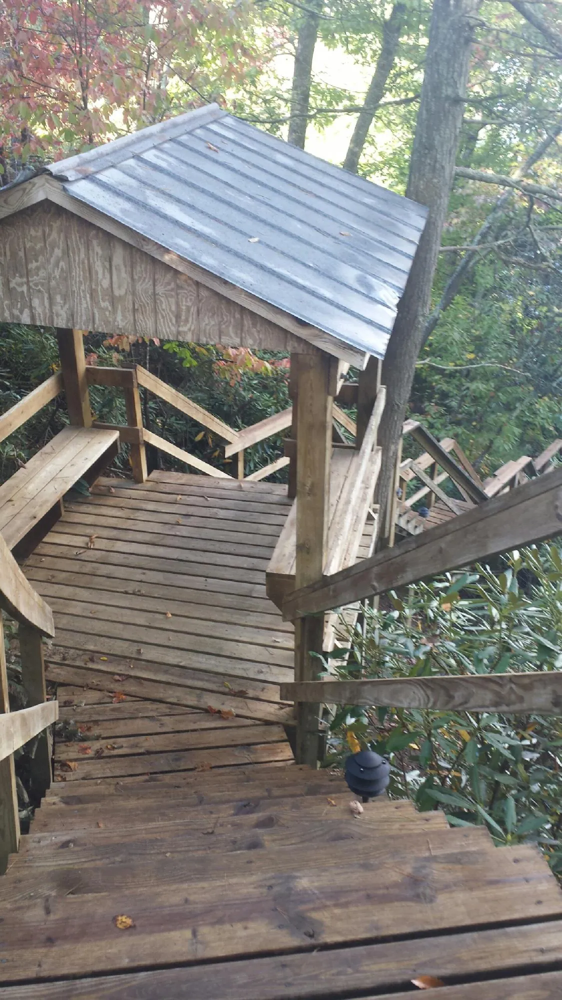 Metal roofed shelter over wooden steps on a wooded walkway — Skylight Repair & Installation work by our crew in Syosset