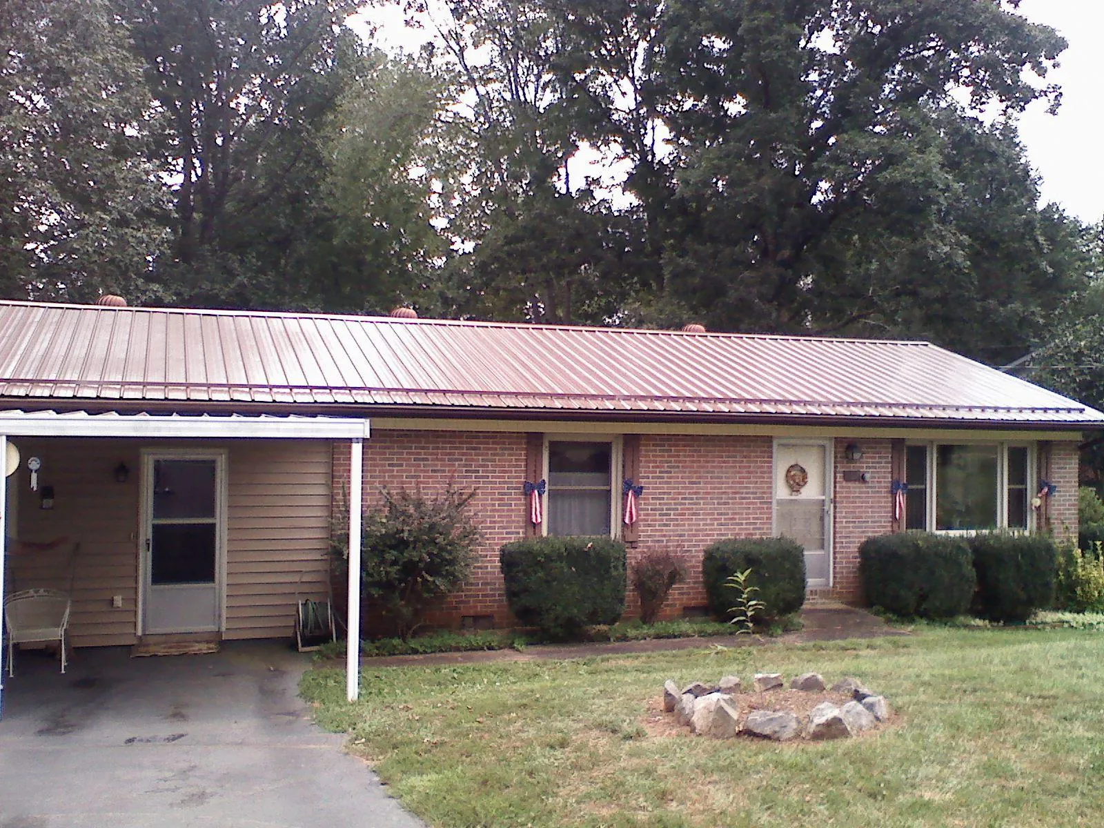 Bronze metal roof and carport on a brick ranch home — Roof Repair work by our crew in Syosset